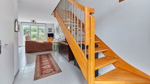 Ein modernes Interieur mit einer Holztreppe, einem Essbereich und Blick auf Grün.