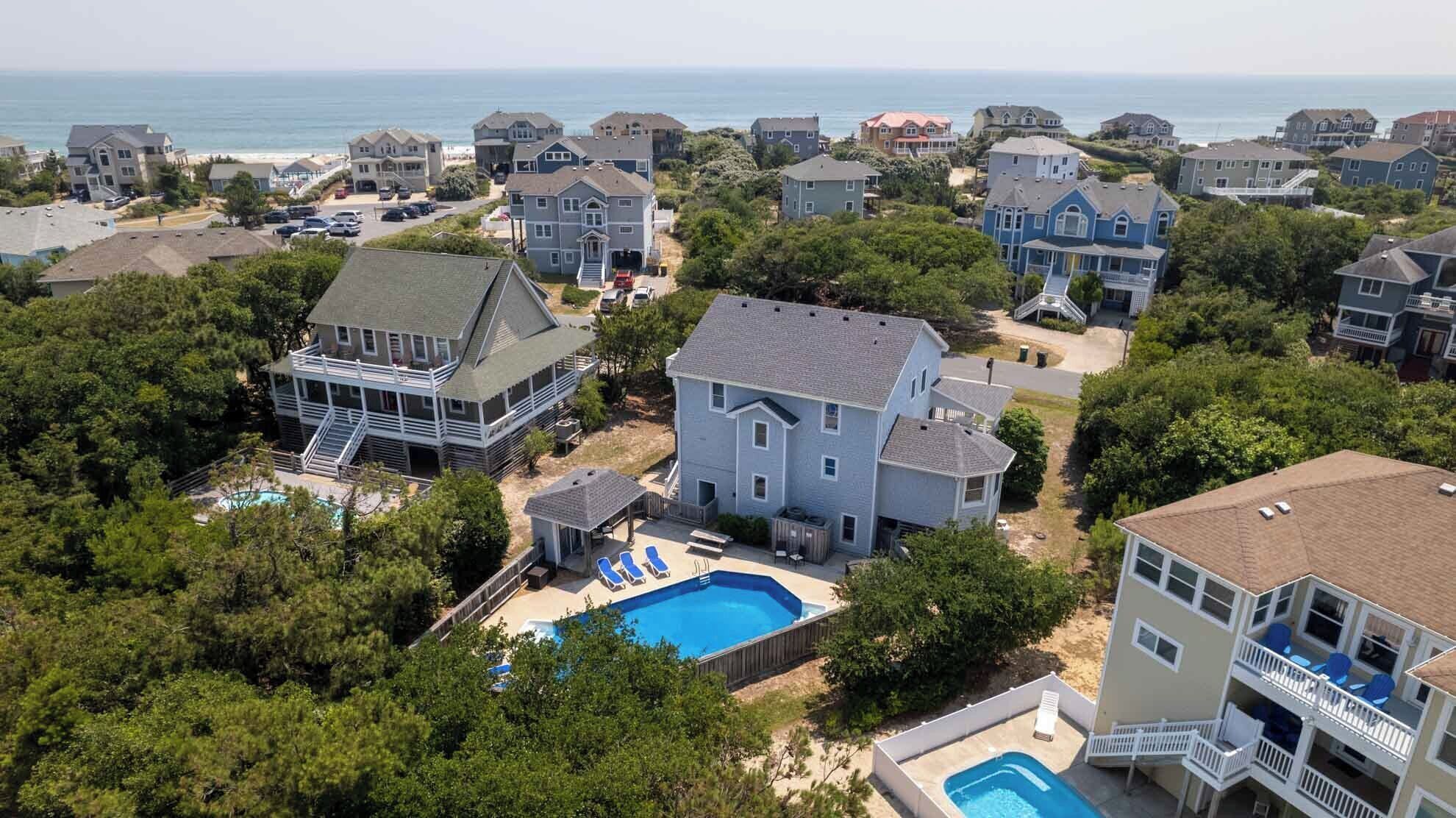 Un quartiere residenziale con case, una piscina e vista sull'oceano.