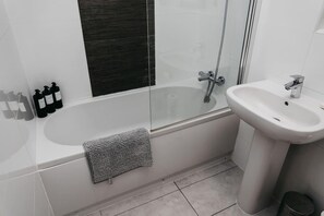 Appartement | Badkamer | Een bad/douchecombinatie, een diep bad, een haardroger, handdoeken