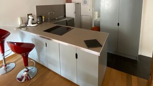 A modern kitchen with a central island, wooden beams on the ceiling, and a refrigerator. - Syunning, spacious & calm. 60m squared in the heart of Avignon  (Avignon)