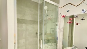 A modern bathroom with a glass-enclosed shower, a white sink, and a mirror above it. - Syunning, spacious & calm. 60m squared in the heart of Avignon  (Avignon)