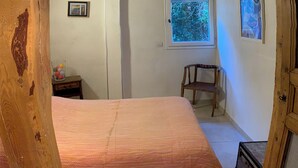 A bedroom with a bed, a window, a chair, and a small table. - Syunning, spacious & calm. 60m squared in the heart of Avignon  (Avignon)