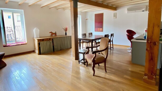 A spacious room with wooden flooring, a dining table with chairs, a kitchen area, and a large window providing natural light. - Syunning, spacious & calm. 60m squared in the heart of Avignon  (Avignon)