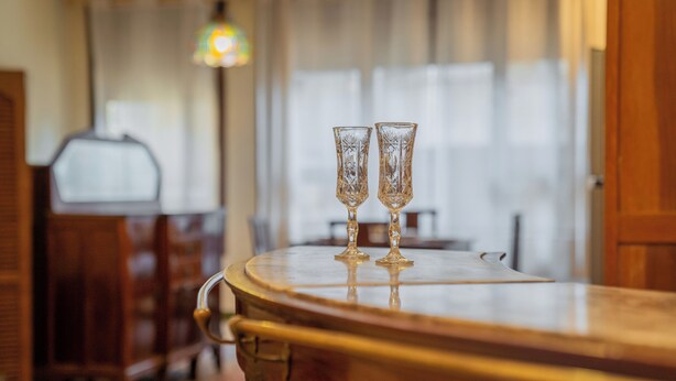 Een bar met twee heldere glazen op een houten toonbank.