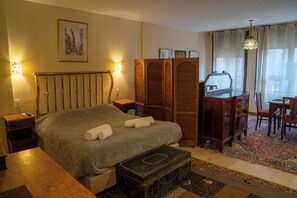 Ein Schlafzimmer mit Bett, Nachttischen, einem Schminktisch, einem Schreibtisch und einem Stuhl.