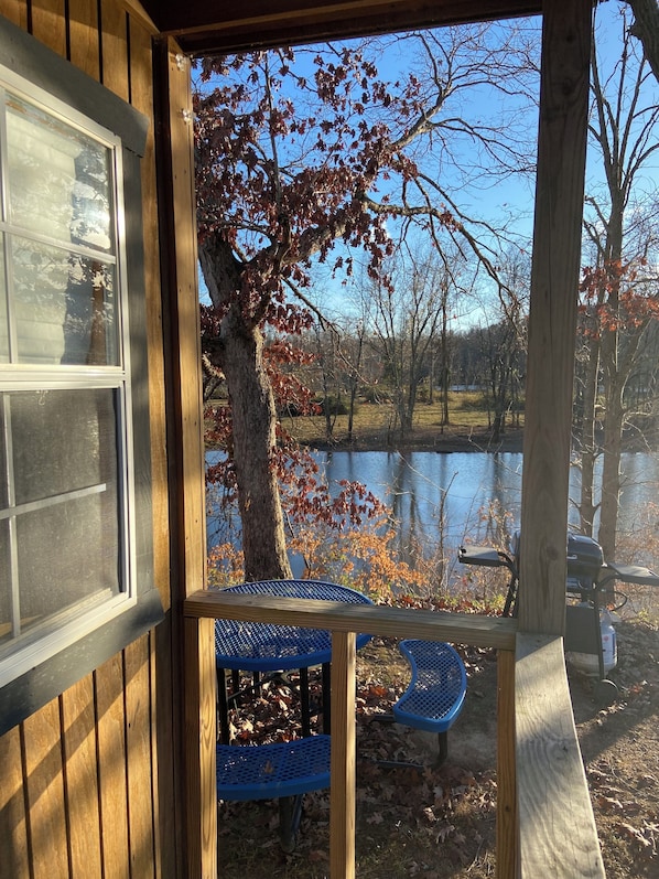 A wooden deck with a view of a lake and trees.