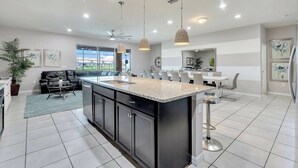 A modern kitchen with a central island, black cabinetry, and pendant lighting. - Cozy home with private pool (8809) (Kissimmee)