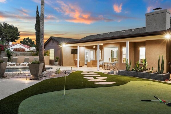 Enjoy a round of golf in the backyard putting green and relax by the small pool on the covered porch.