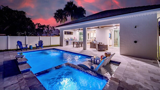 Piscina com hidromassagem, área de estar ao ar livre e um terraço coberto.
