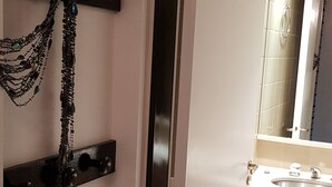 Un baño con un lavamanos blanco, un espejo y un adorno en la pared.