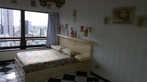 Un dormitorio con cama, ventana y adornos en la pared.