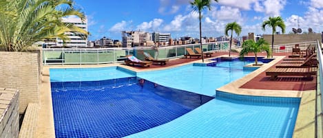 Una piscina techada, sillones reclinables de piscina