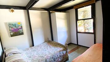 Ein Schlafzimmer mit einem Bett, einem Fenster und einem Gemälde an der Wand.