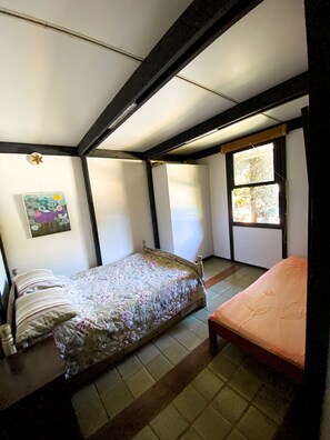 A bedroom with a bed, a window, and a painting on the wall. - Chácara Espetacular em Ibiúna (Ibiuna)