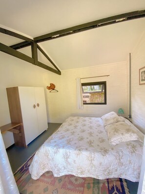 A bedroom with a bed, a wardrobe, a window with a view, and a hanging light fixture. - Chácara Espetacular em Ibiúna (Ibiuna)