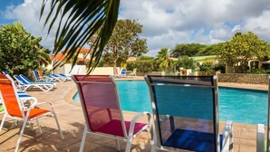 A pool area with lounge chairs and a clear view of the pool. - 03 Kas Koral by Bonaire Paradise (Kralendijk)