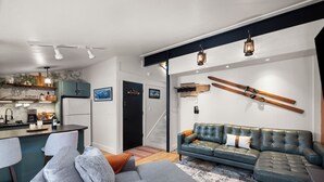 A modern living space with a kitchen, dining area, and a large gray sofa. - Ascend Remodeled Condo, SummerFun, Bear&Alpine Lake, across musical festival (Bear Valley)