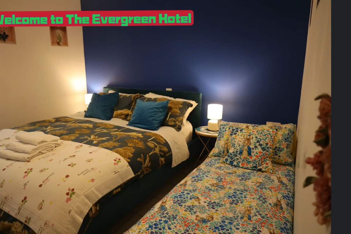 A hotel room with a large bed, two bedside tables, and a nightstand.