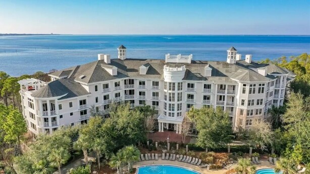 A large, multi-story hotel with a pool area, surrounded by trees and overlooking a body of water. - Bahia at Sandestin Studio 3rd Floor Pool View ! (Miramar Beach)