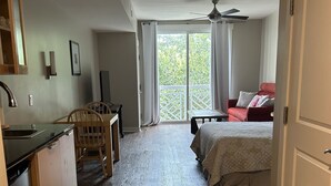 A compact room with a kitchenette, a dining area, a bed, and a sliding glass door leading to a balcony. - Bahia at Sandestin Studio 3rd Floor Pool View ! (Miramar Beach)