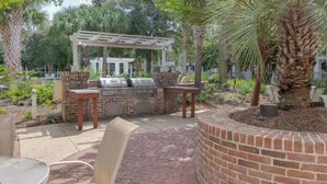 An outdoor patio with a brick barbecue area, seating, and a pergola. - Bahia at Sandestin Studio 3rd Floor Pool View ! (Miramar Beach)
