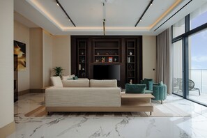 A modern living room with a sofa, a flat-screen TV, and a bookshelf.