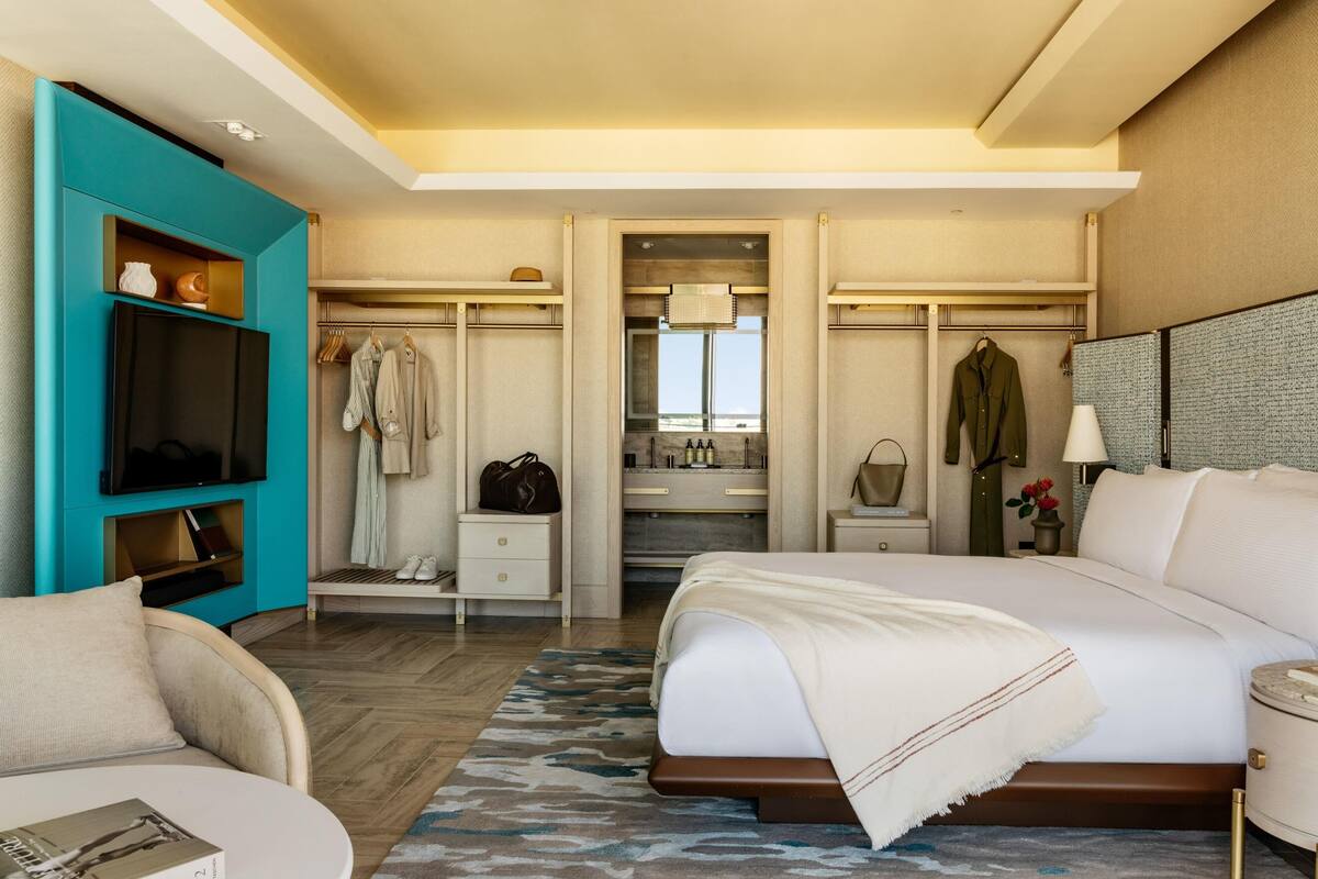 A hotel room with a bed, a TV, a closet, a bathroom, and a view.