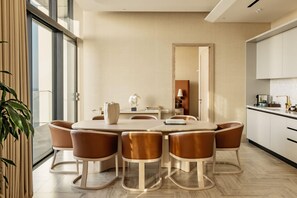 A modern dining area with a round table, six chairs, and a large mirror. - Me Malta (St. Julian's)