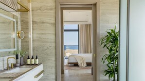 Un baño moderno con tocador de mármol, un espejo grande y zona de ducha.