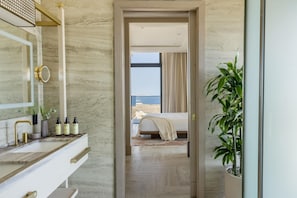 A modern bathroom with a marble vanity, a large mirror, and a shower area.