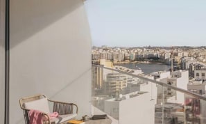 A balcony with a view of a cityscape and a river.