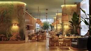 Un amplio vestíbulo de hotel con techos altos, ventanas grandes y una zona de comedor central.