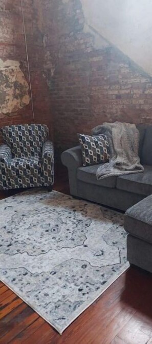 Relax in this inviting space with a patterned armchair, plush sofa, and warm rug.