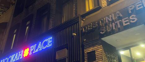 Un edificio con un letrero que dice "Hookah Place" y otro letrero que anuncia "Pennsylvania Pennies Suites".