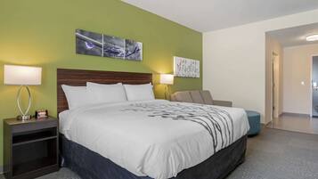 A hotel room with a large bed, two bedside tables with lamps, and artwork on the walls.