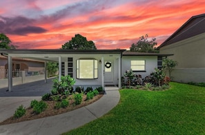 A modern single-story house with a covered porch, a garage, and a well-maintained lawn.