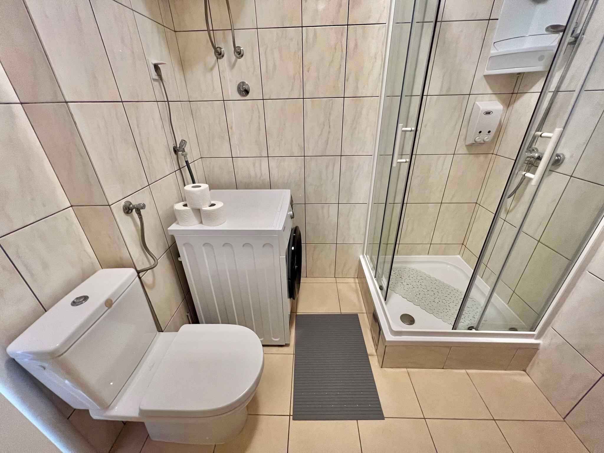 Ein Badezimmer mit Toilette, Waschbecken, Dusche und einer separaten Duschkabine.