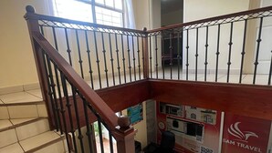 A staircase with wooden handrails and black balusters, leading to an upper floor. - SAM Travel Managua, Centrico de la Ciudad Capitalina (Managua)