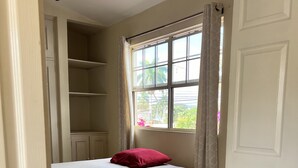 A bedroom with a bed, a window with curtains, a door, and a tiled floor. - SAM Travel Managua, Centrico de la Ciudad Capitalina (Managua)