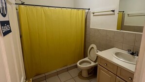 A small bathroom with a toilet, sink, and mirror. - SAM Travel Managua, Centrico de la Ciudad Capitalina (Managua)