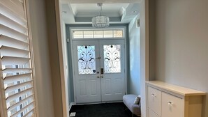 A hallway with a double door, a chandelier, and a light-colored cabinet. - Cozy 5 Bedroom House in Mississauga, On  (Mississauga)