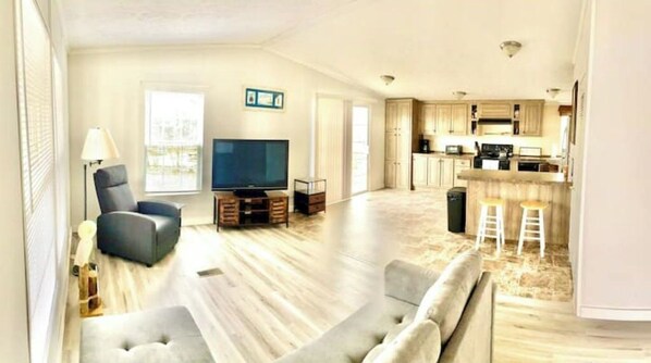 Relax in this stylish living area with a large flat-screen TV, comfortable sofa, and matching ottoman.