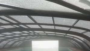 An indoor swimming pool with a clear view through the roof, surrounded by a metal frame. - Amplio Departamento con Vistas a la Montaña, ¡con Ski-in y Ski-out ! (Santiago)