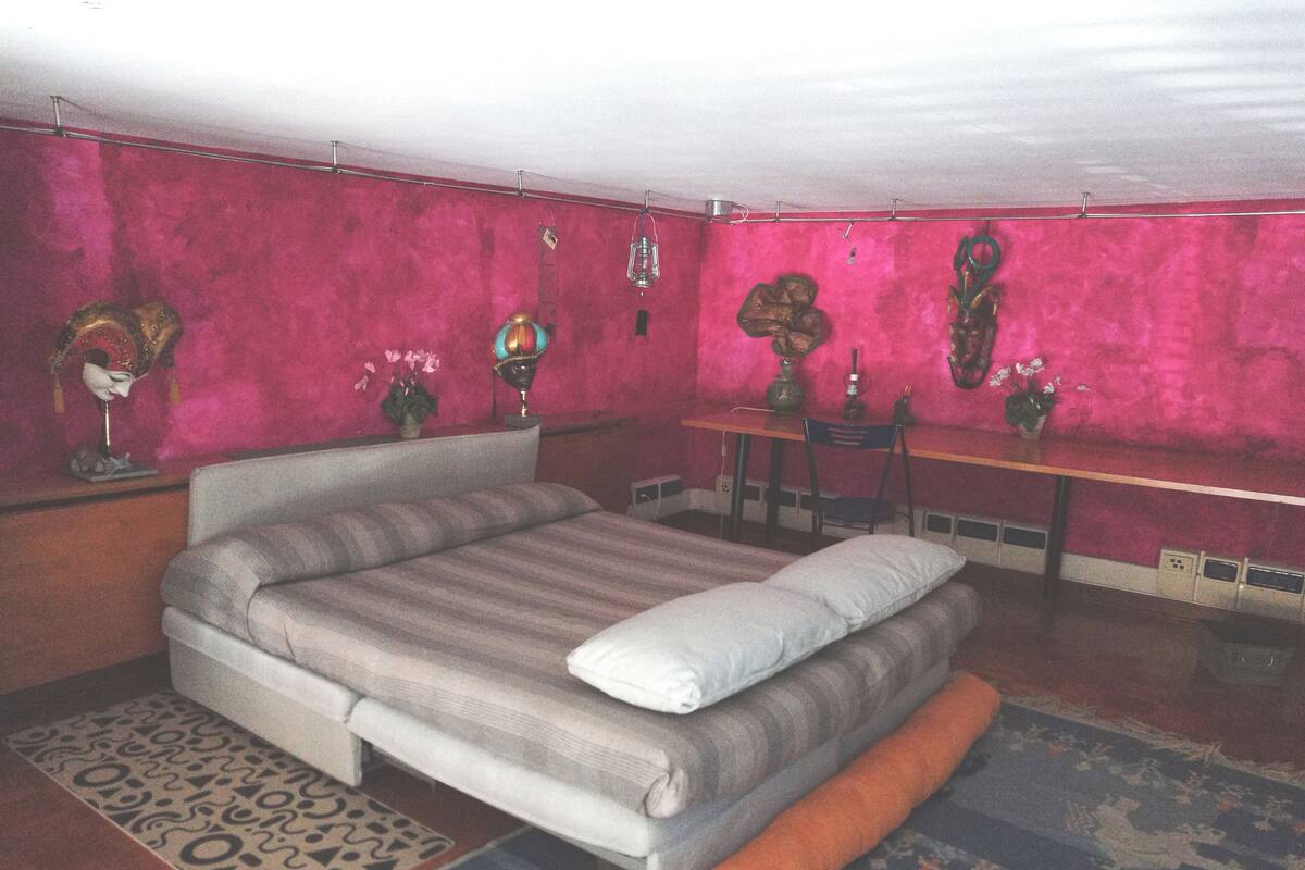 A bedroom with a bed, a desk, and a chair.