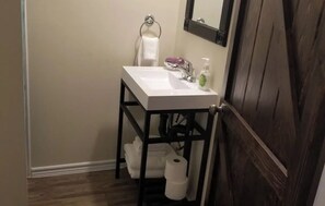 A compact bathroom with a sink, towel, and mirror.