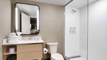 Un baño moderno con inodoro, lavamanos y ducha.