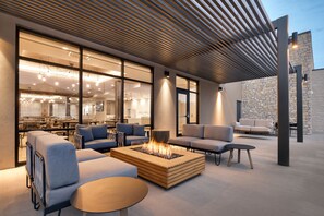 An outdoor seating area with a fire feature, sofas, and a table. - TownePlace Suites by Marriott Show Low (Show Low)