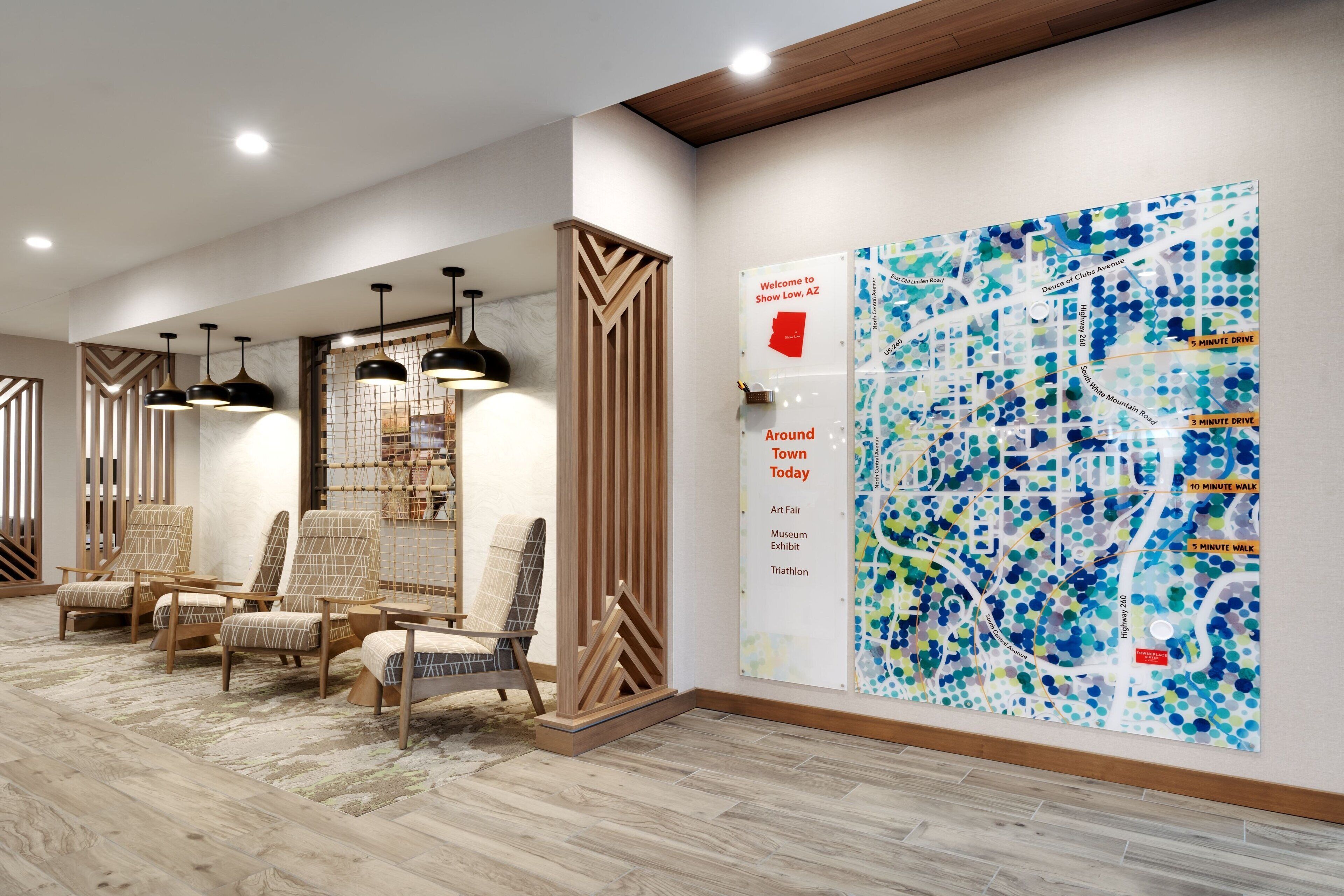 A modern lobby with seating, a large map, and a welcome sign.