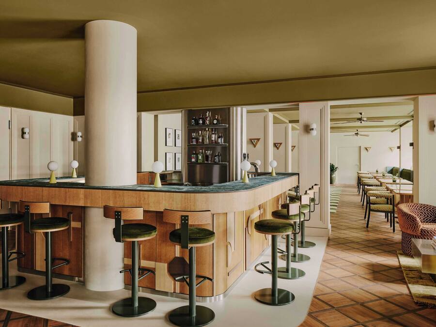 A bar area with stools, a central column, and a kitchen counter.