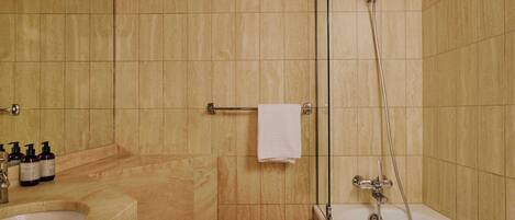 Un baño con bañera, ducha, lavamanos e inodoro.